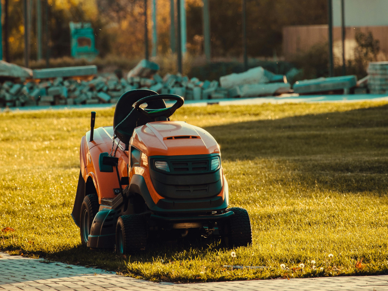 red lawn mower in grass golden hour